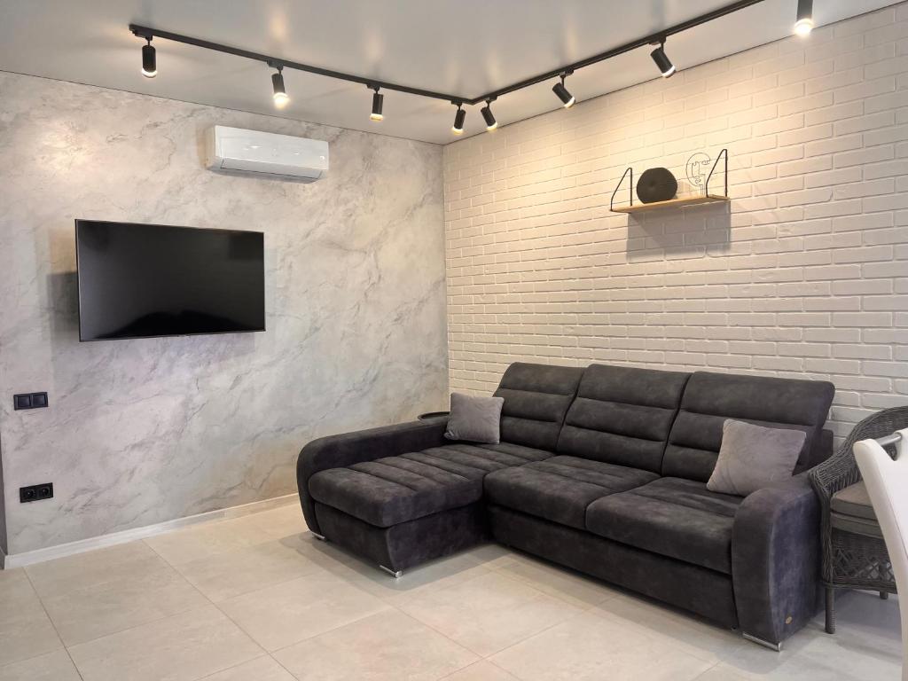 a living room with a leather couch and a flat screen tv at Golden Bugas Sea View Золотий бугаз in Karolino-Buhaz