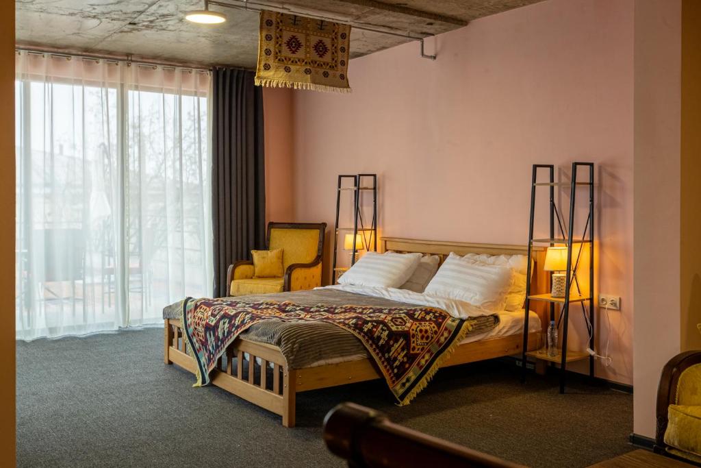 sypialnia z łóżkiem i 2 żółtymi krzesłami w obiekcie Residence Kavkasioni w mieście Telawi