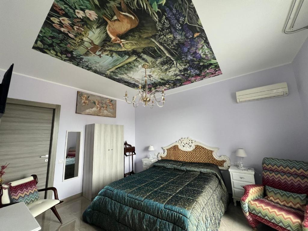 een slaapkamer met een bed en een schilderij aan het plafond bij Villa GIOBEA in Favara
