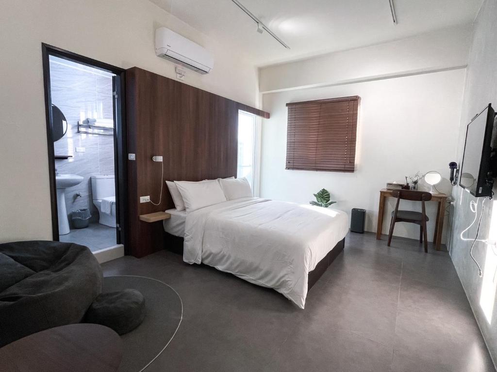 una camera da letto con un letto bianco e una porta scorrevole in vetro di 木子寓所 Moozhouse a Magong