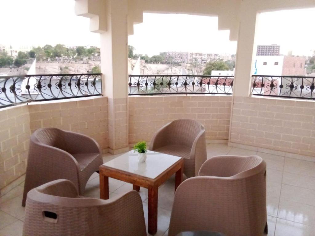 a room with chairs and a table and some windows at Nile palace in Jazīrat Aswān