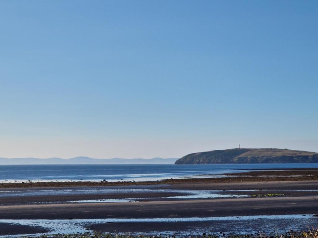Ein Strand mit dem Meer und Bergen im Hintergrund in der Unterkunft Number34 in Drummore