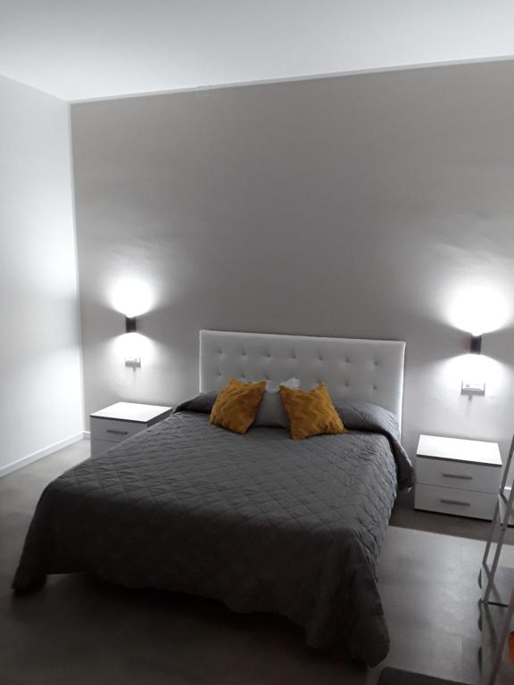 a bedroom with a large bed with two night stands at Kamome Rooms in Agrigento