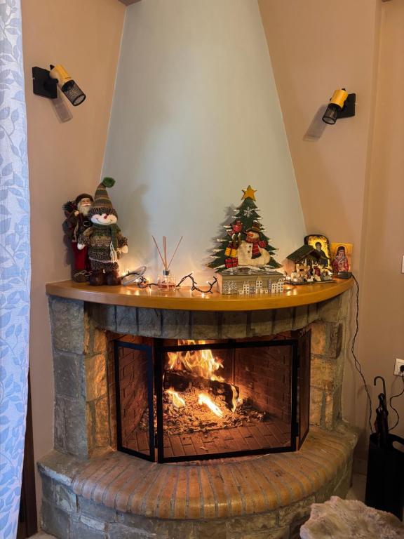 a fireplace with a christmas tree on top of it at Kalavryta Moments in Kalavrita