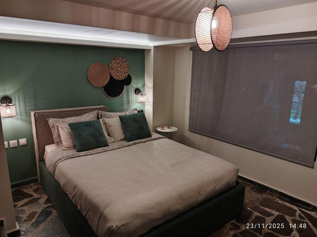 a bedroom with a bed with a large screen at Φεγγαρόπετρα ΓΑΙΟΦΩΣ in Kalívia