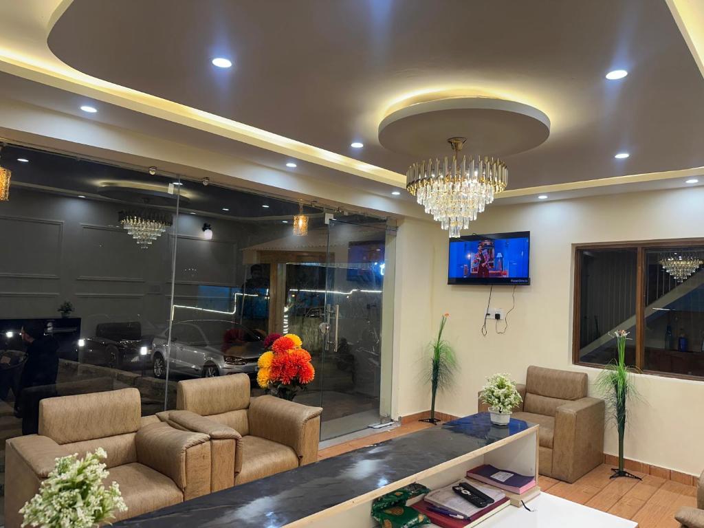 un soggiorno con un divano e un lampadario di The Blue Park By OSCAR a Manāli