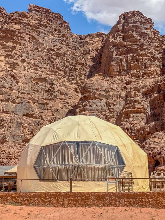 a dome tent in front of a rock wall at Mira Bubble Luxury Camp in Wadi Rum
