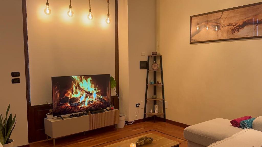 ein Wohnzimmer mit einem TV und einem Kamin darauf in der Unterkunft Loft 84 in Piacenza