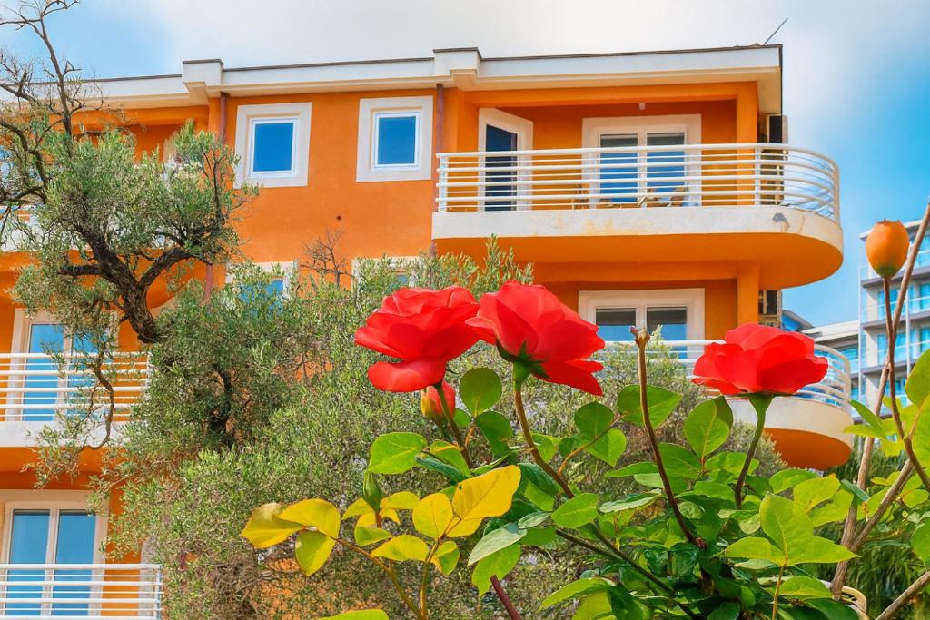 an orange building with red flowers in front of it at Better place in Bečići