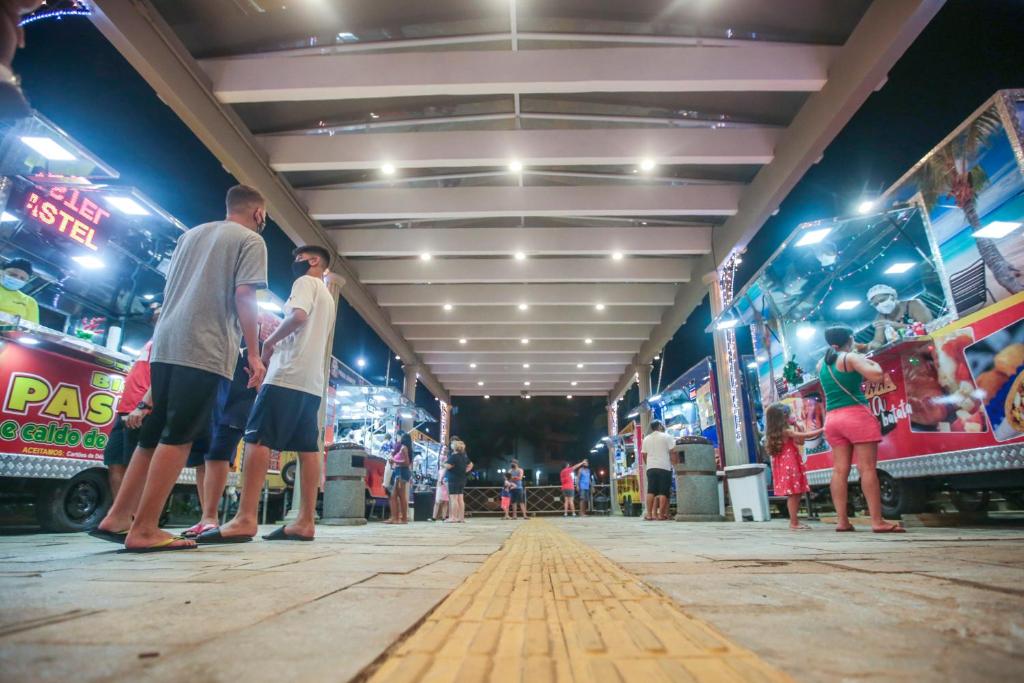 een groep mensen die voor een speelhal staan bij Kitão Caiçara in Praia Grande