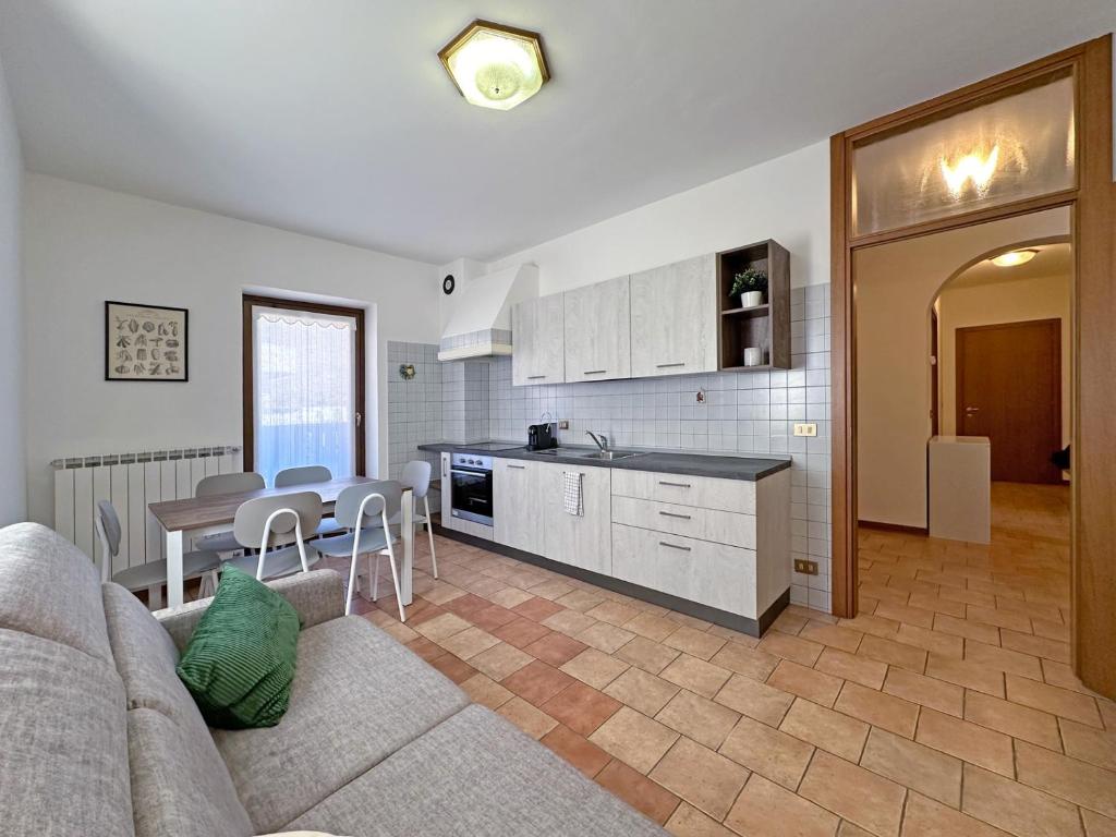 a kitchen and living room with a couch and a table at BBkey Borgo Living Sutrio in Sùtrio