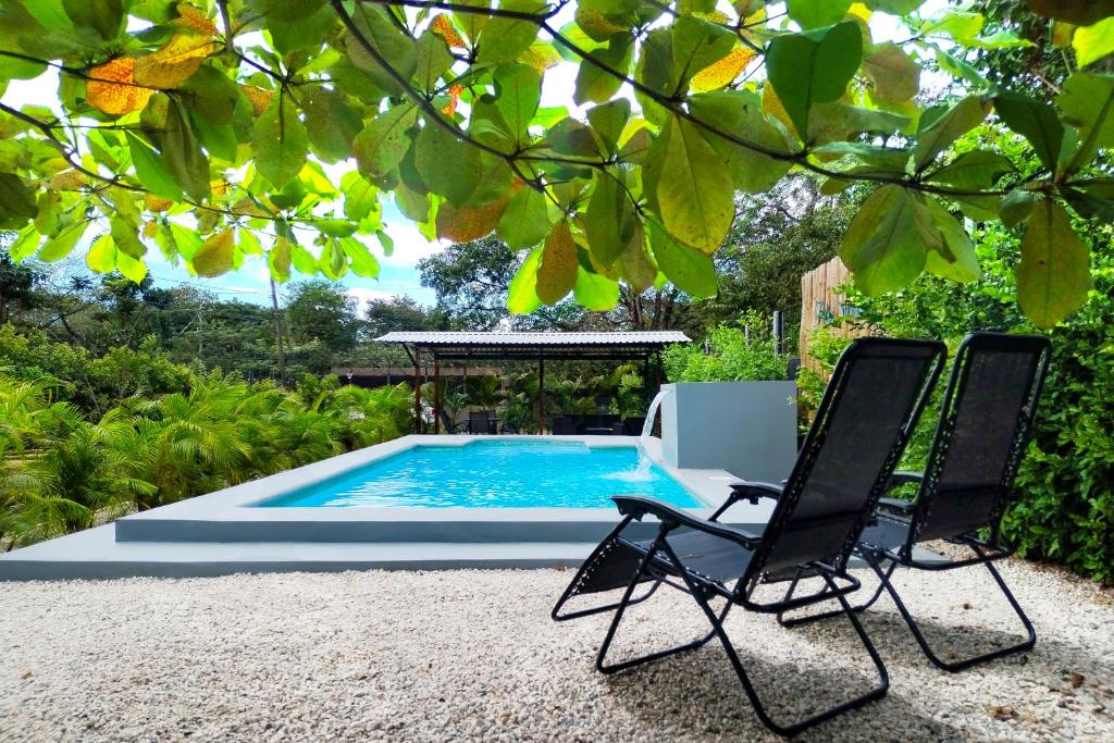 two chairs sitting next to a swimming pool at BlueStone Residence in Brasilito