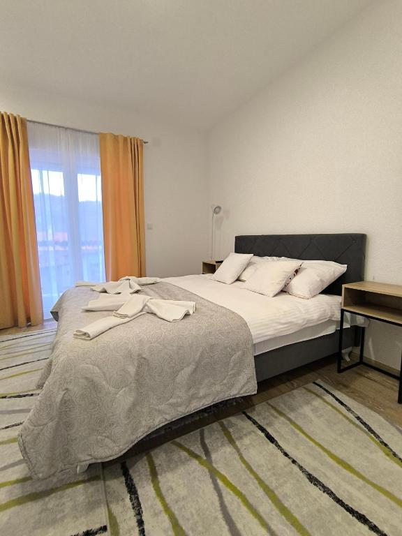 a bedroom with a large bed and a window at TOKIs apartmani in Mrkonjić Grad