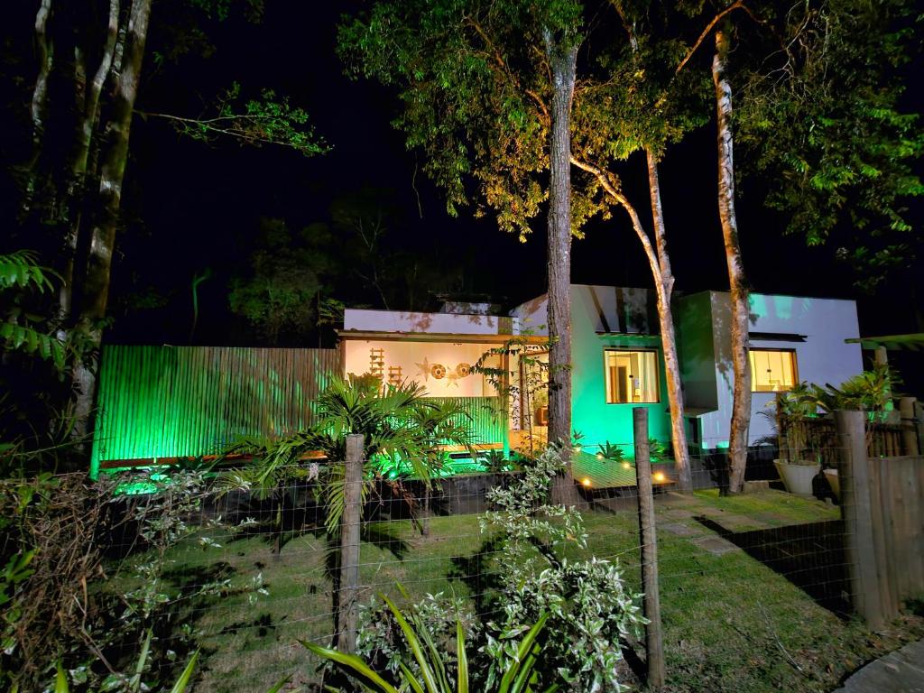 een huis met groene lichten in de tuin 's nachts bij Maison CATU in Itacaré