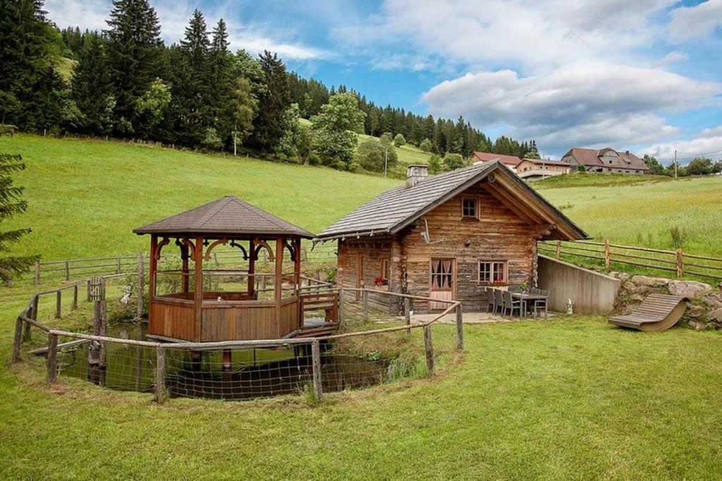 a log cabin with a gazebo in a field at Hüblerhütte in Lading