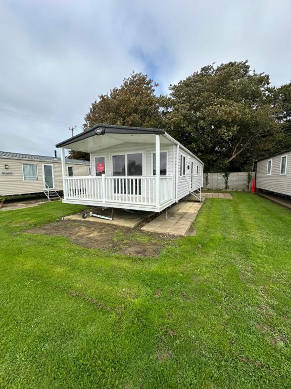 a white mobile home in a yard at Church meadow 39 in Pagham