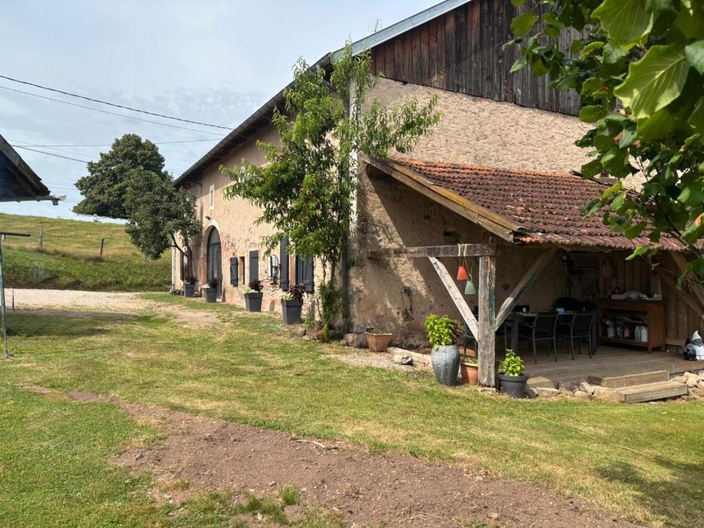 een schuur met een tafel en stoelen erbuiten bij La Bulle d Avenir in Corcieux