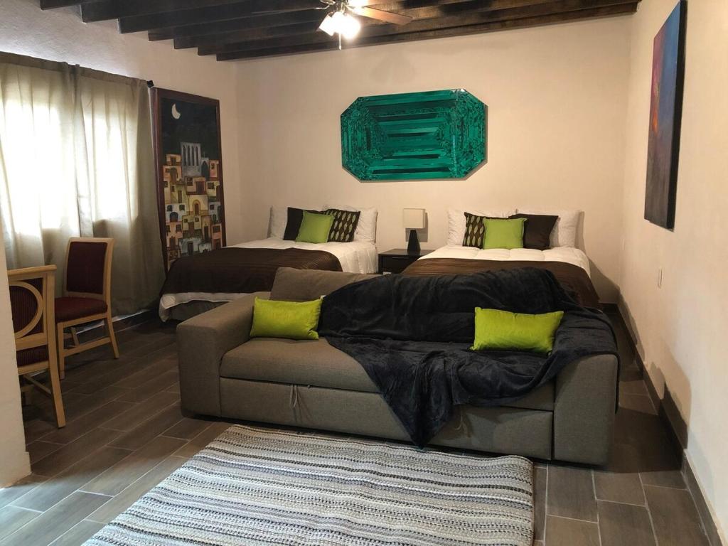 un soggiorno con un divano e due letti di Casa del Olivo Suite 2 a Parras de la Fuente