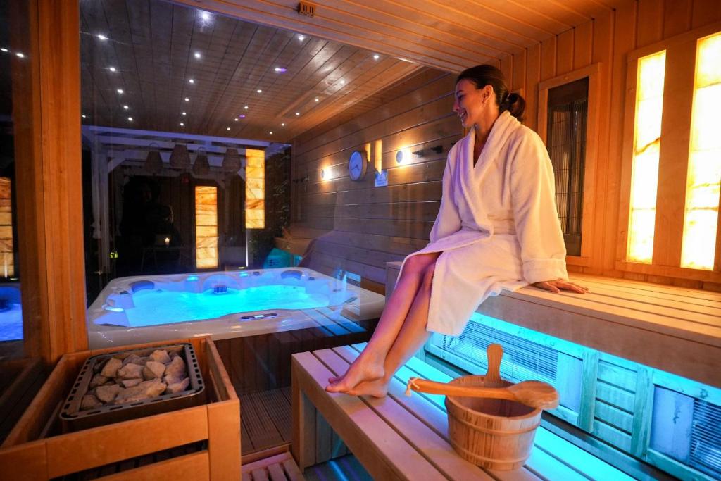 een vrouw die op de rand van een bad zit bij ChaChaCha House Vendégház in Egerszalók