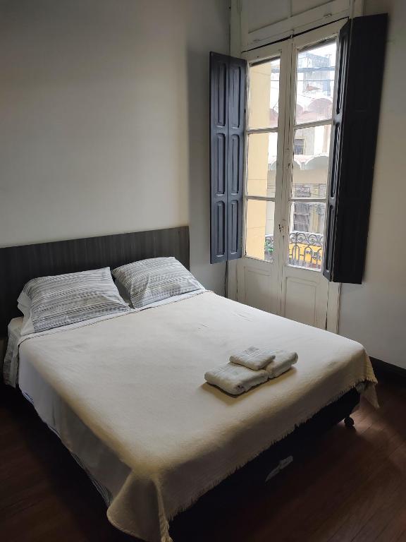 a bedroom with a bed with two towels on it at Hostal Vampayá in Salta