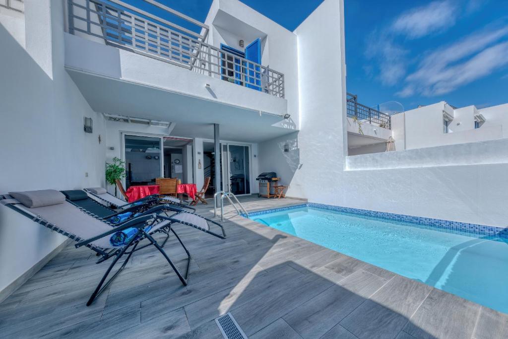 a villa with a swimming pool and a house at Villa Mariña- Heated pool in Playa Blanca