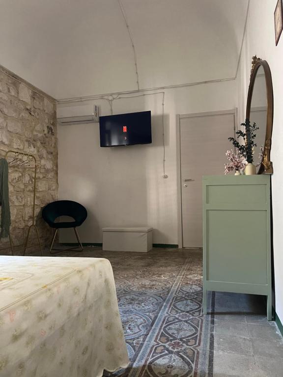 ein Zimmer mit einem Bett und einem Fernseher an der Wand in der Unterkunft Le Millesime du Soleil in Rosolini