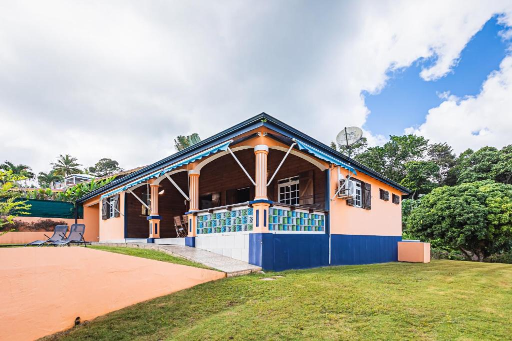 una casa con un blu e un bianco di Villa Sofaia à sainte-rose, 9 pers, 3 chambres, vue mer et montagne, piscine privée a Sainte-Rose