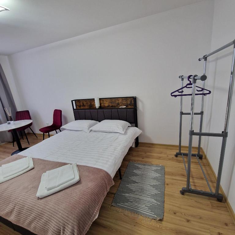 a bedroom with two beds and a table and chairs at Maria Central Studio in Târgu Neamț