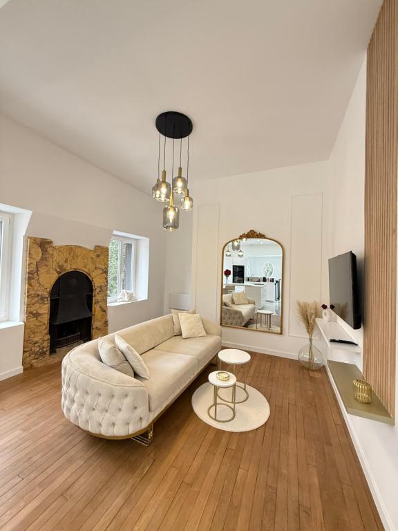 a living room with a couch and a mirror at Sublime logement neuf in Thaon-les-Vosges