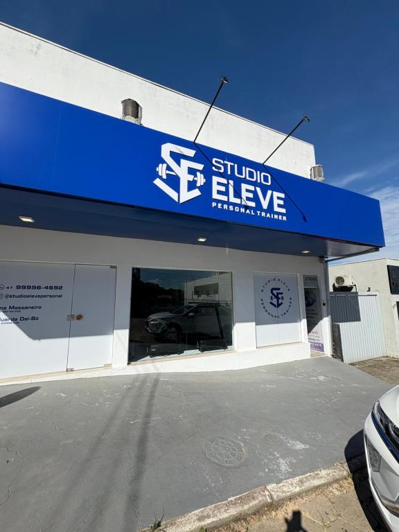 een winkel met een blauw bord erop bij 1o Andar Apartamento in Canoinhas