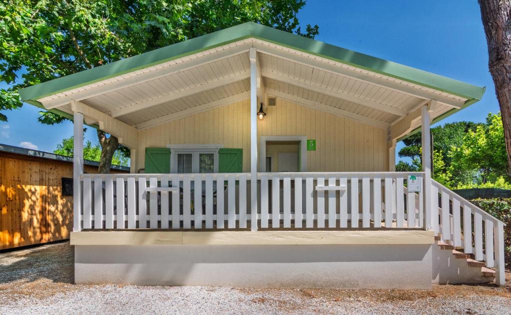 a small yellow house with a green roof at Camping Parco Vacanza Partaccia 2 in Marina di Massa