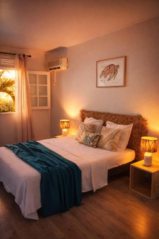 a bedroom with a large bed with two lamps at Résidence Yacinthe in Le Robert