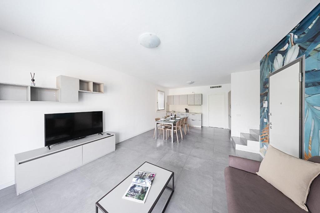 un salon avec une télévision, un canapé et une table dans l'établissement Villa Prestige, à Sirmione