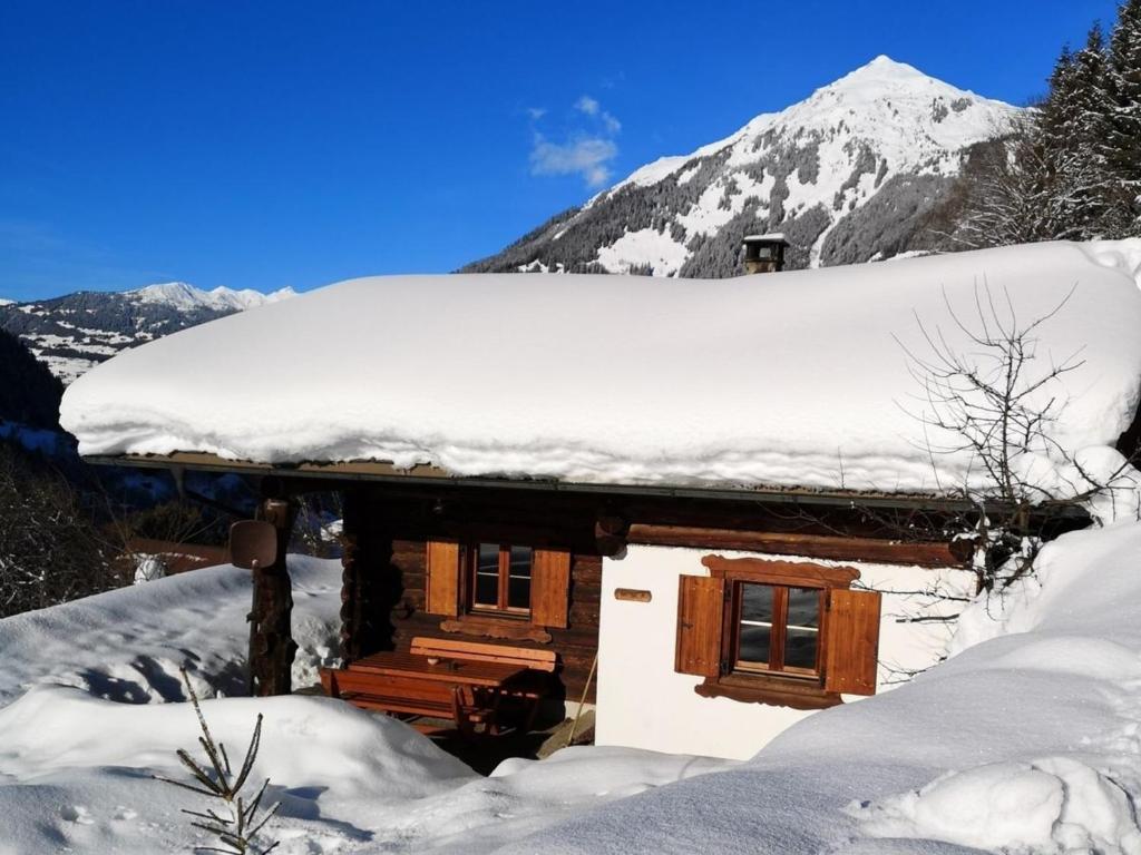 a cabin in the snow with a snow covered roof at Hütta Monika in Sankt Gallenkirch
