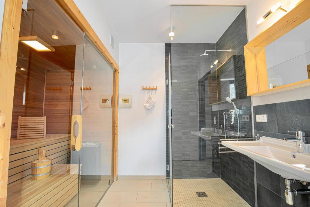 a bathroom with a glass shower and a sink at Strandhaus Meeresperle in Ostseebad Sellin