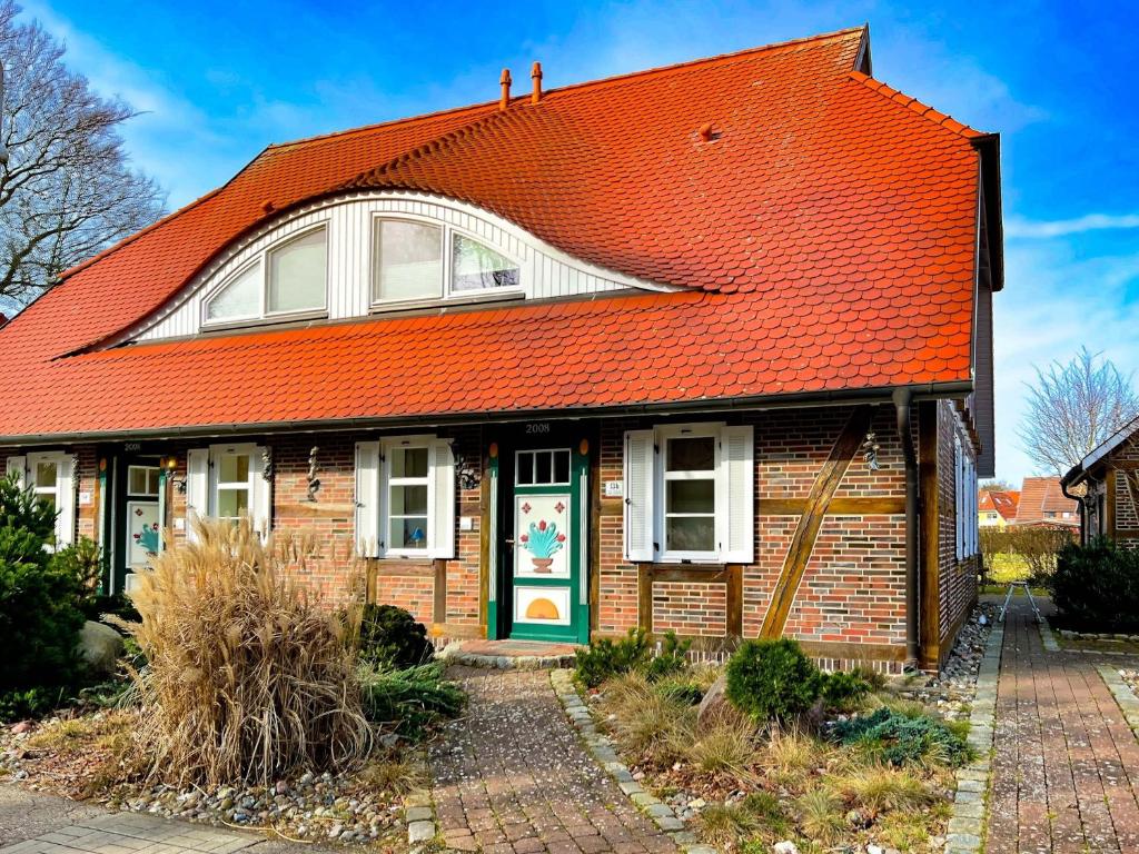 an orange roofed house with a green door at Wellnessoase in Prerow