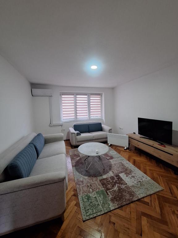 ein Wohnzimmer mit Sofa und Tisch in der Unterkunft Apartman Mila in Bihać