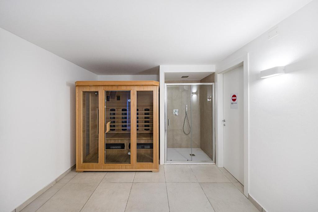 une chambre avec douche et armoire en bois dans l'établissement Villa Prestige, à Sirmione