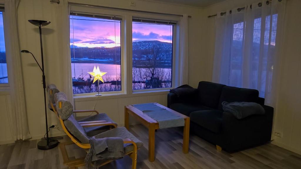 een woonkamer met een bank en een ster in een raam bij Arctic Wonderland in Senja