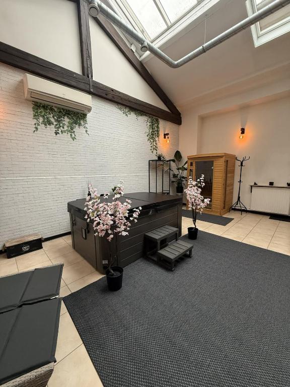 a large room with a piano and flowers in it at Loft Des Sens in Saint-Chamond