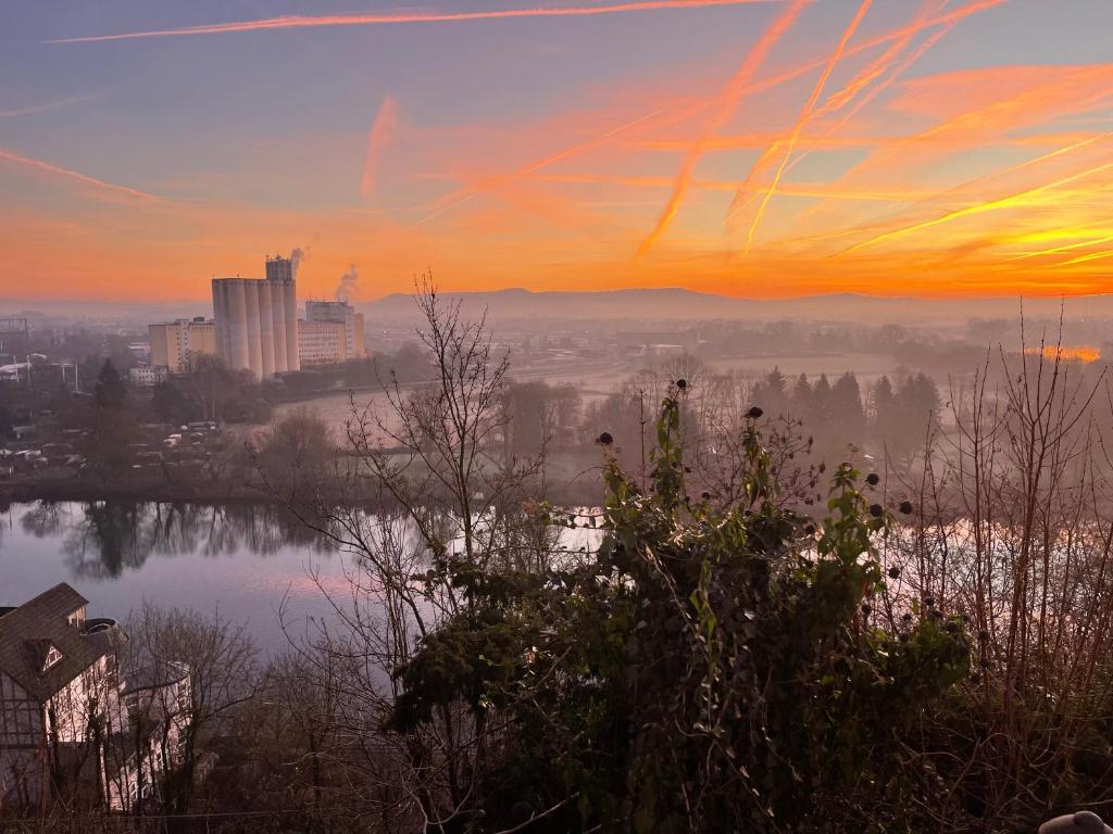 a view of a city at sunset with a lake at Grünes Studio in Hameln