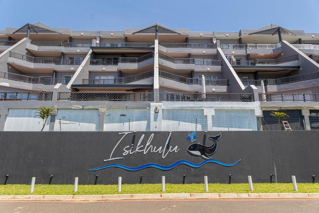 a building with a sign on the side of a wall at Dookes Apartment in Umdloti