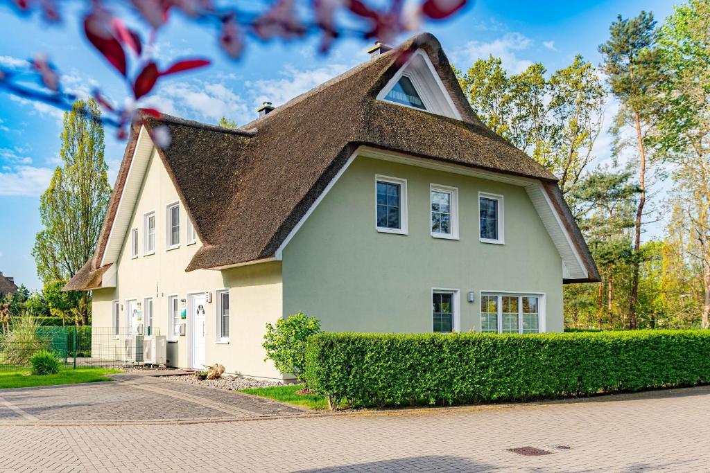 a white house with a brown roof at Ferienhaus Seegras in Groß Kirr