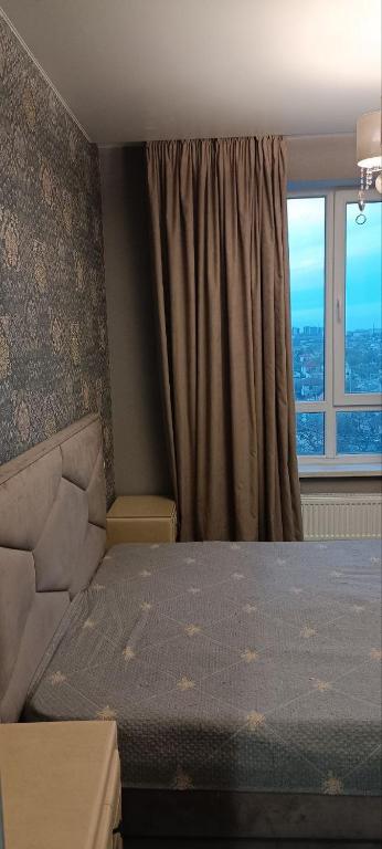 a bedroom with a bed and a window at Aкварель на Черемушках in Odesa