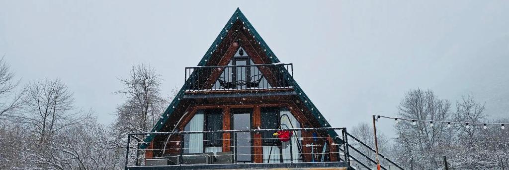 a tall building with a steeple in the snow at Mountain Shadow Cottage in Racha in Ghebi