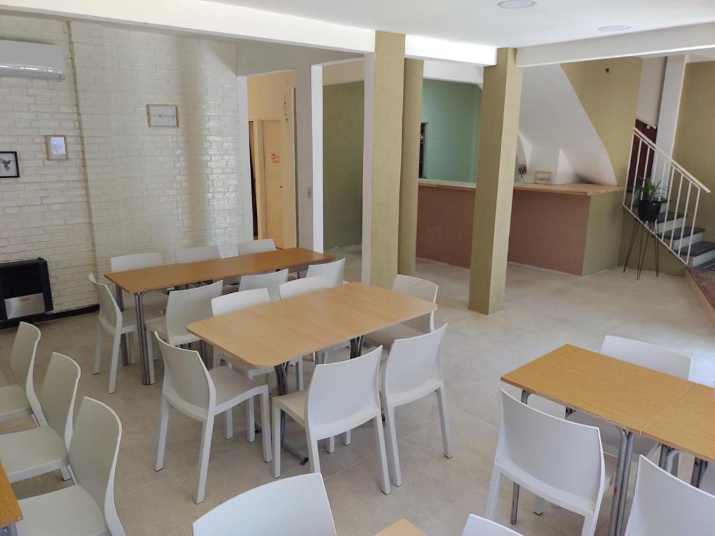 a cafeteria with wooden tables and white chairs at Hotel Riviera in Santa Teresita