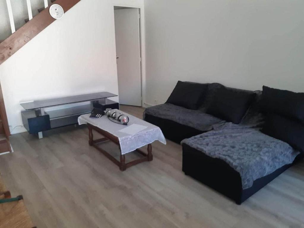 een woonkamer met een bank en een salontafel bij Duplex appartement in Étampes