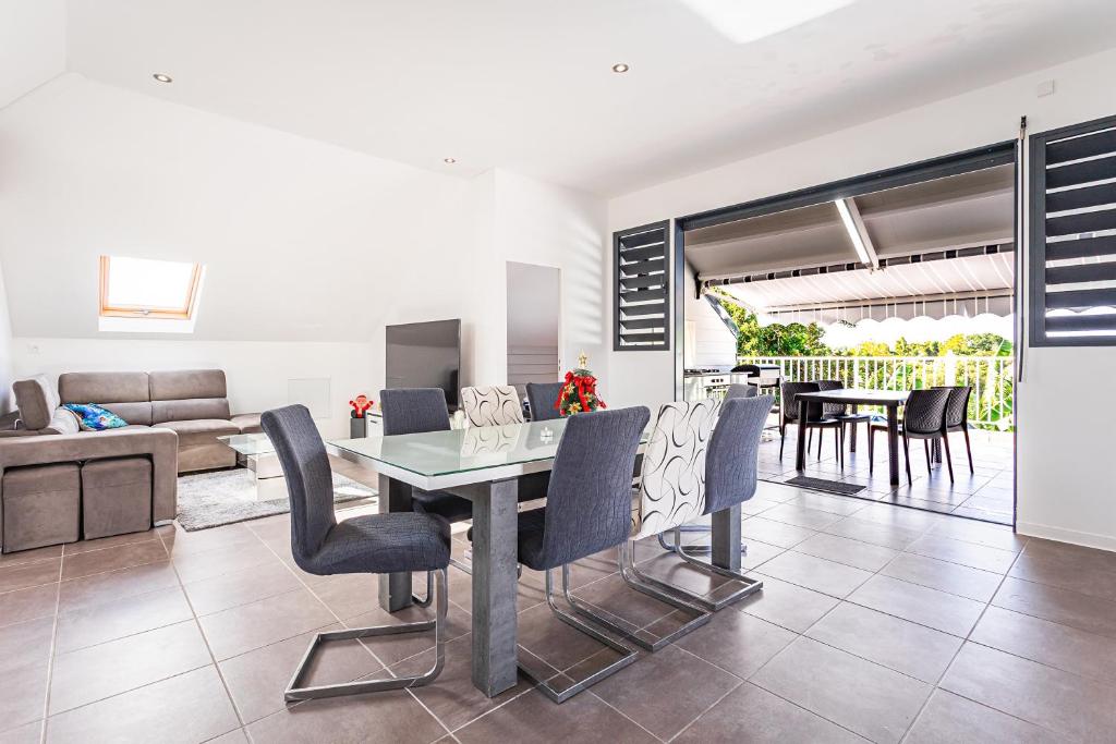 a dining room and living room with a table and chairs at appartement haut standing au grands fonds du moule, 6 pers, très spacieux in Le Moule