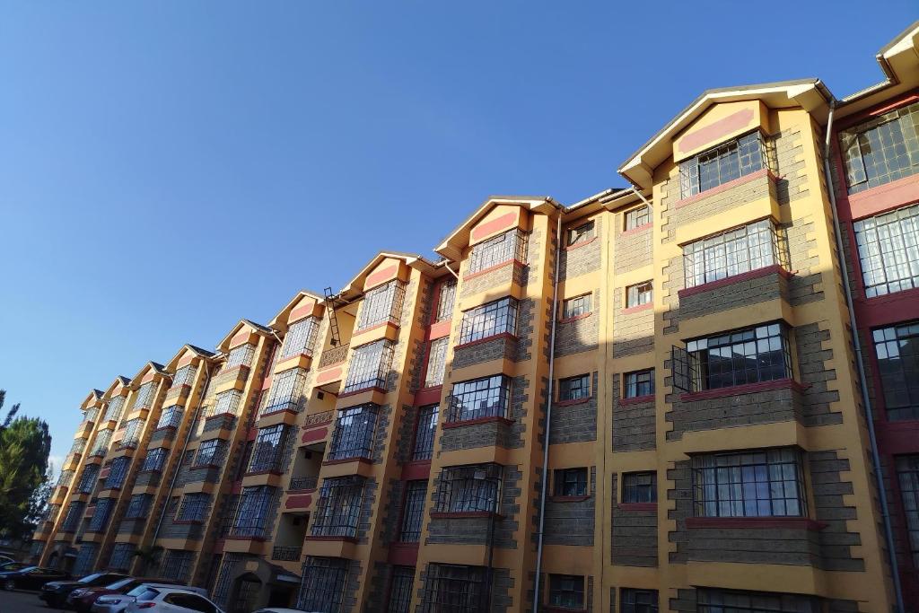an apartment building with many windows on a street at Prissy Apartment in Nairobi