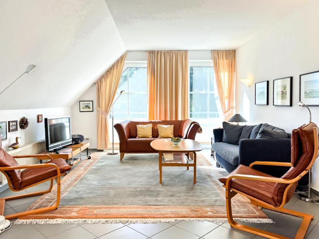 a living room with a couch and a tv at Windwatt 4 in Zingst